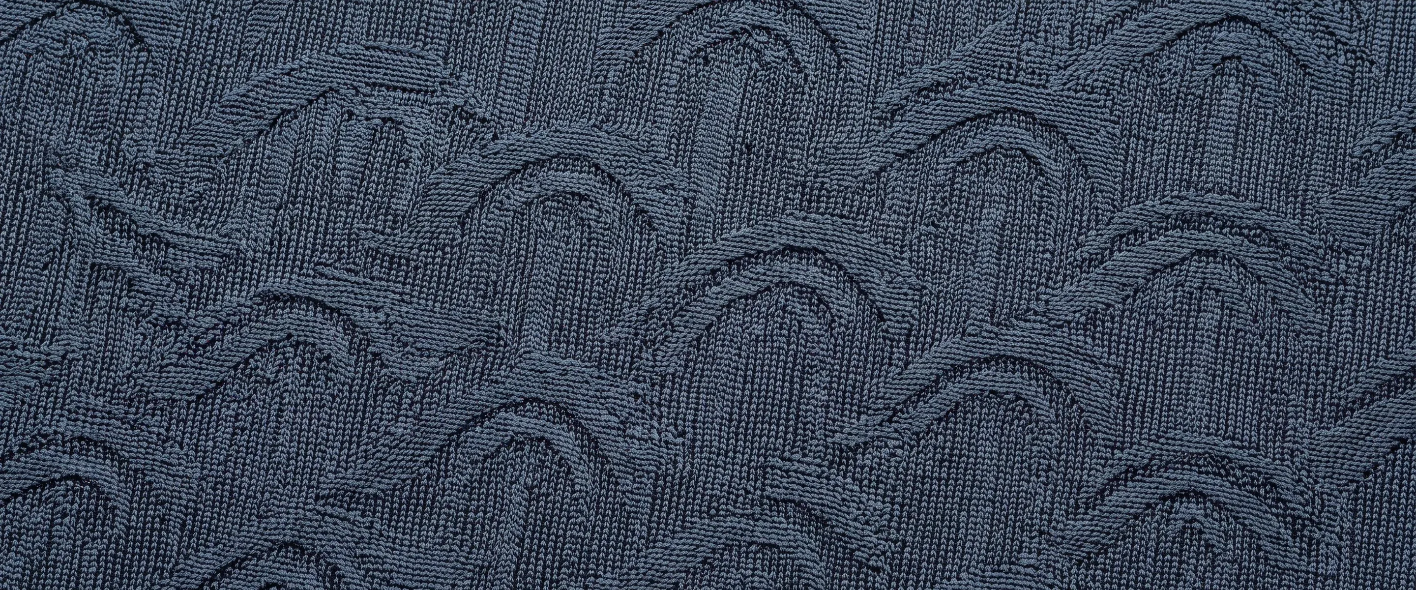 Full-bleed dark slate-blue cloth with a repeating arched jacquard texture