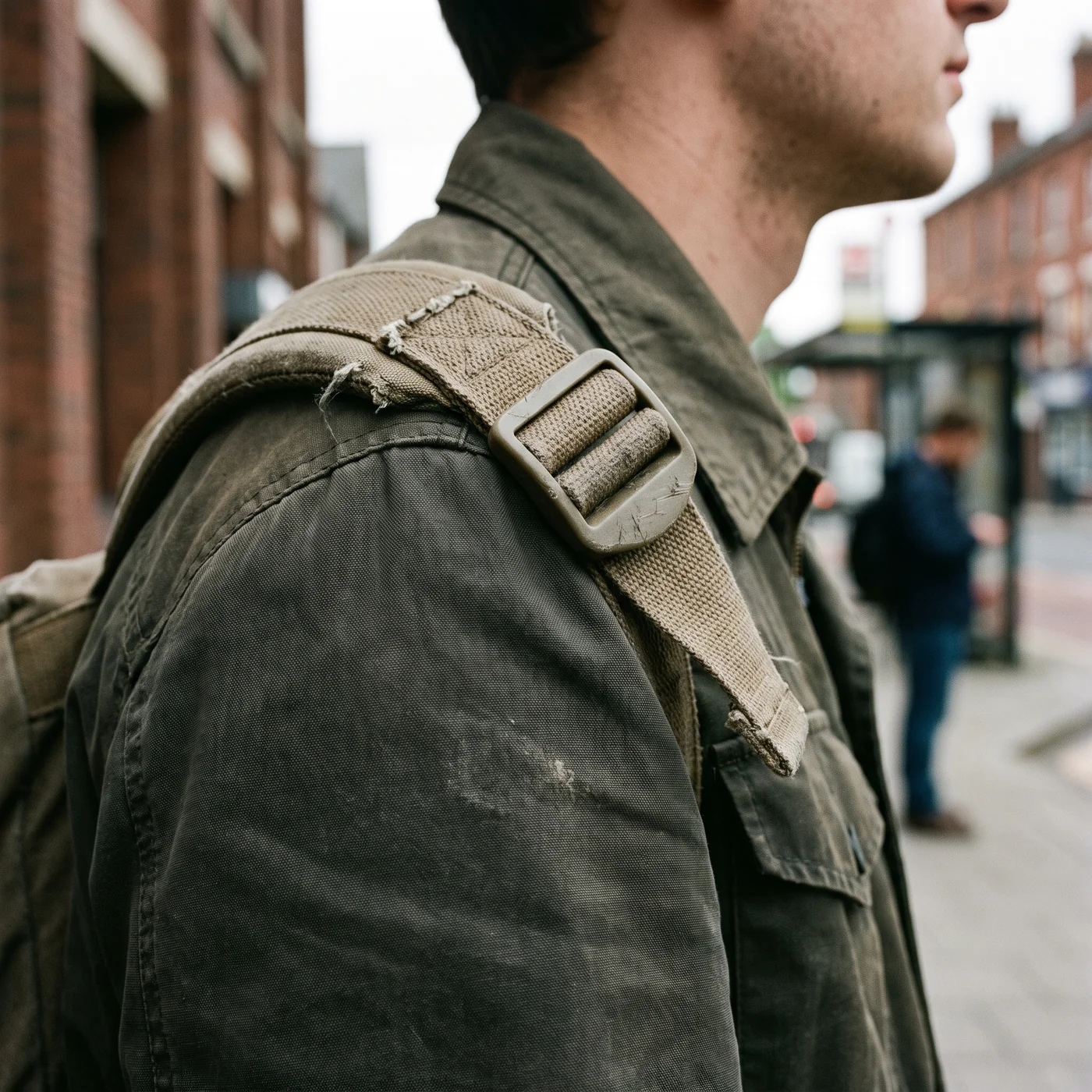 A pack strap and its adjuster hardware, the band that loads the same panel twice a day