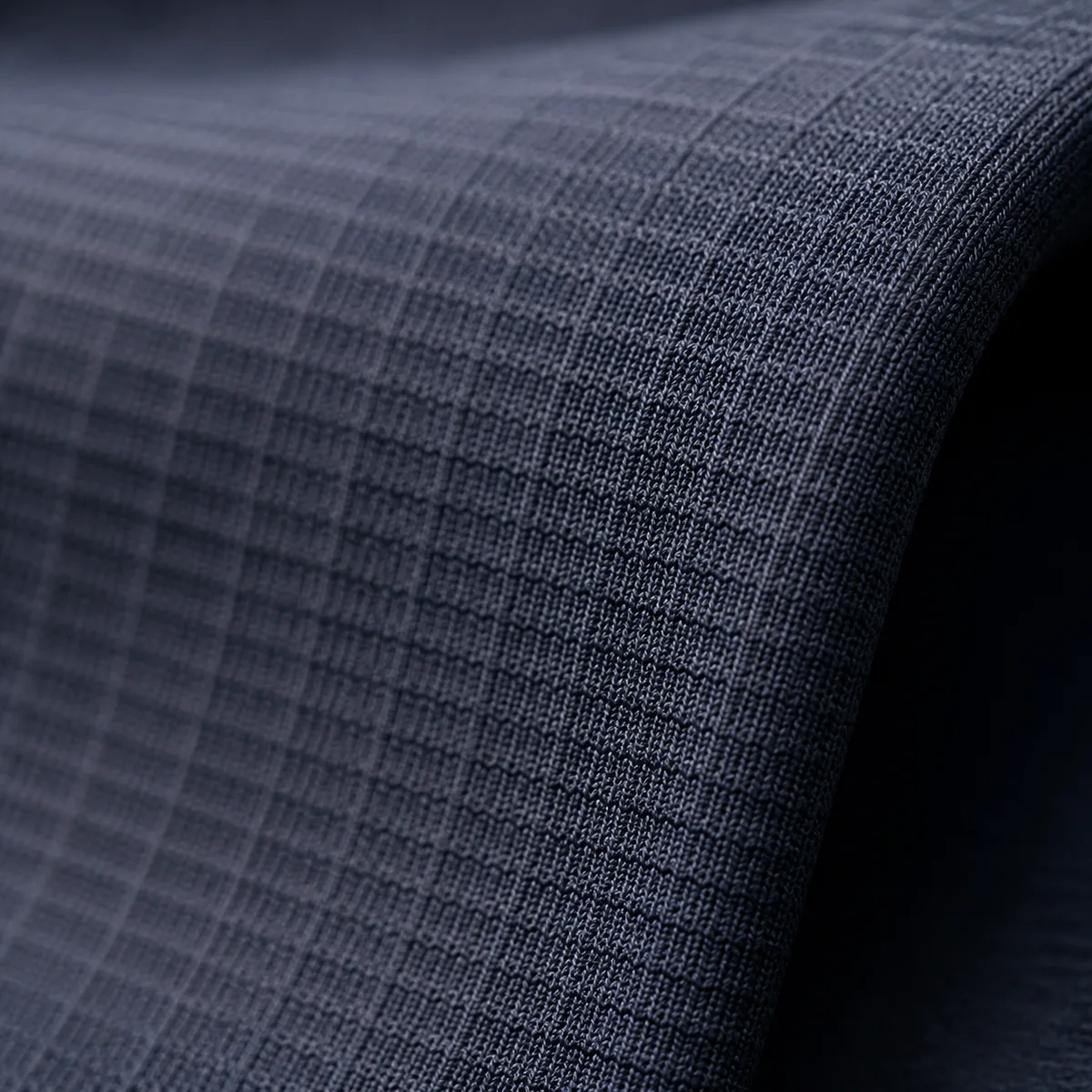 Macro of a reinforced grid-knit body fabric in dark navy