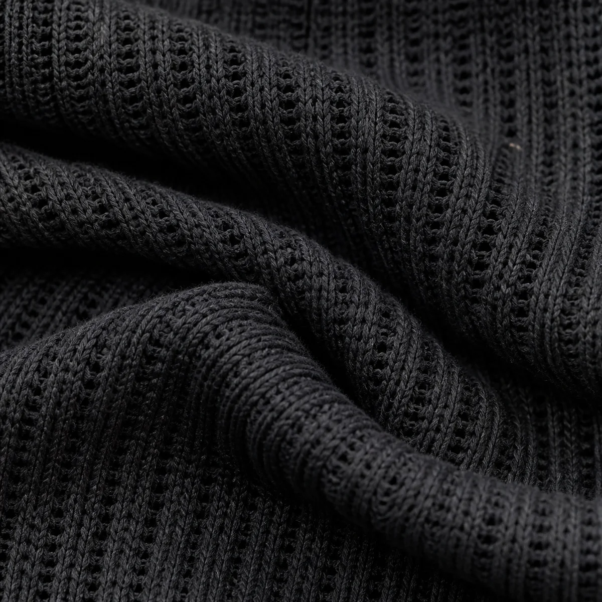 Open rib-knit fabric folded beside its denser counterpart for comparison