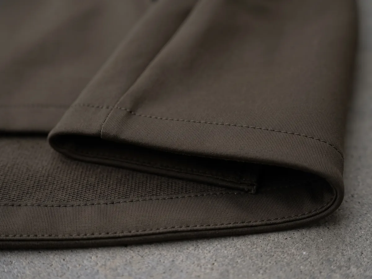 A dark olive-brown smooth fabric folded back on itself