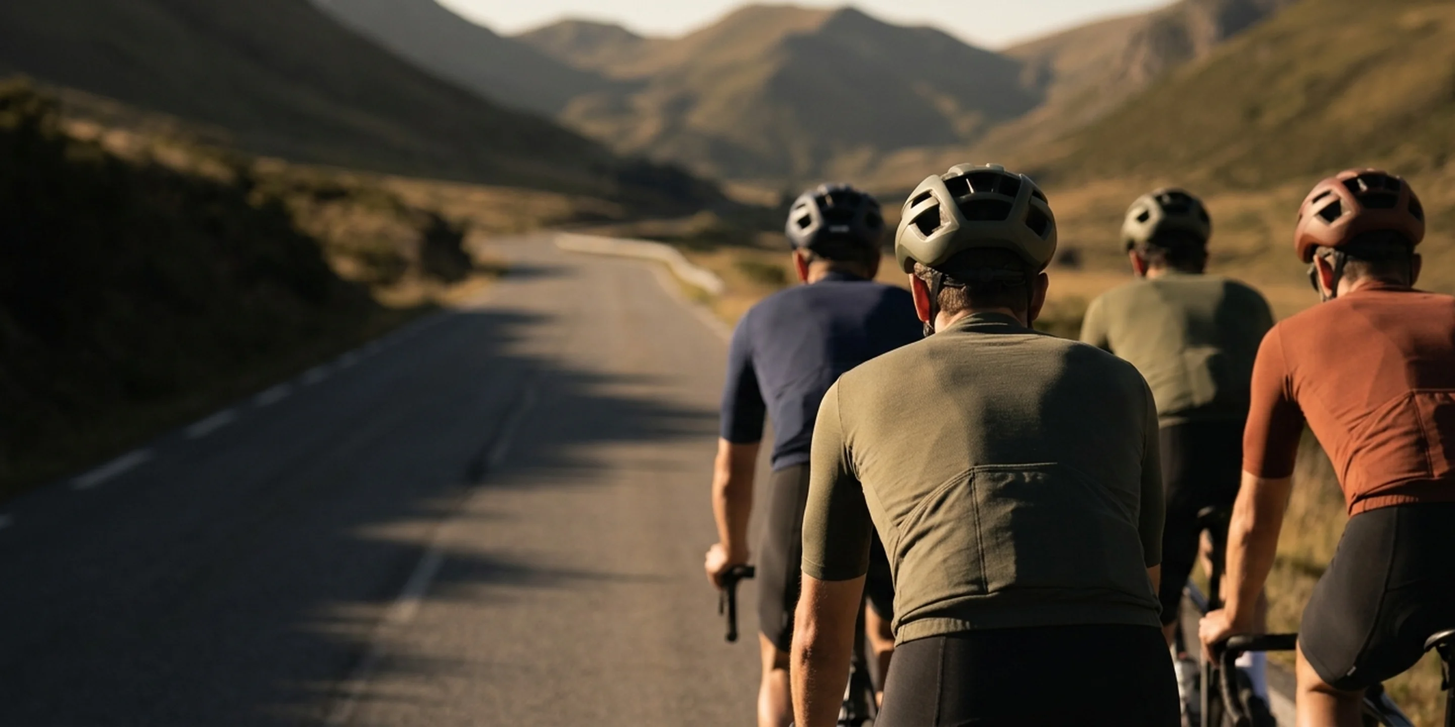 A group of cyclists riding together in matching team kit on an open road