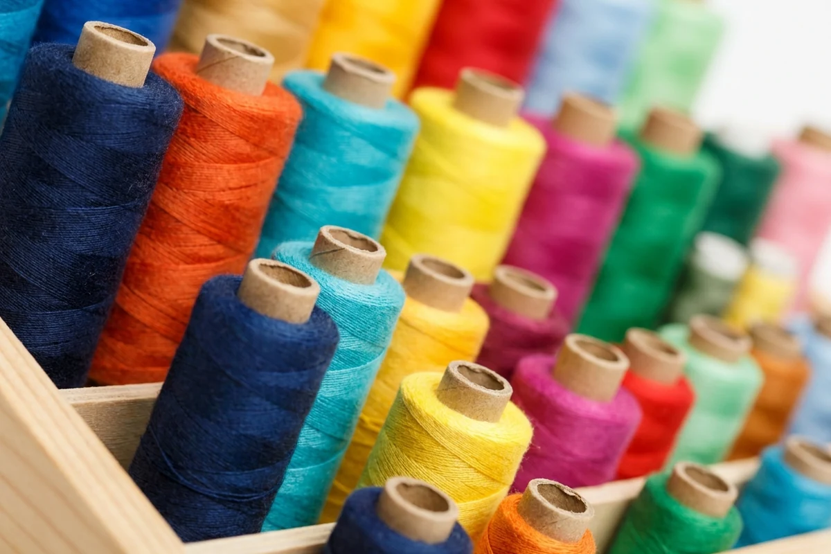 Row of sewing thread spools in many colours