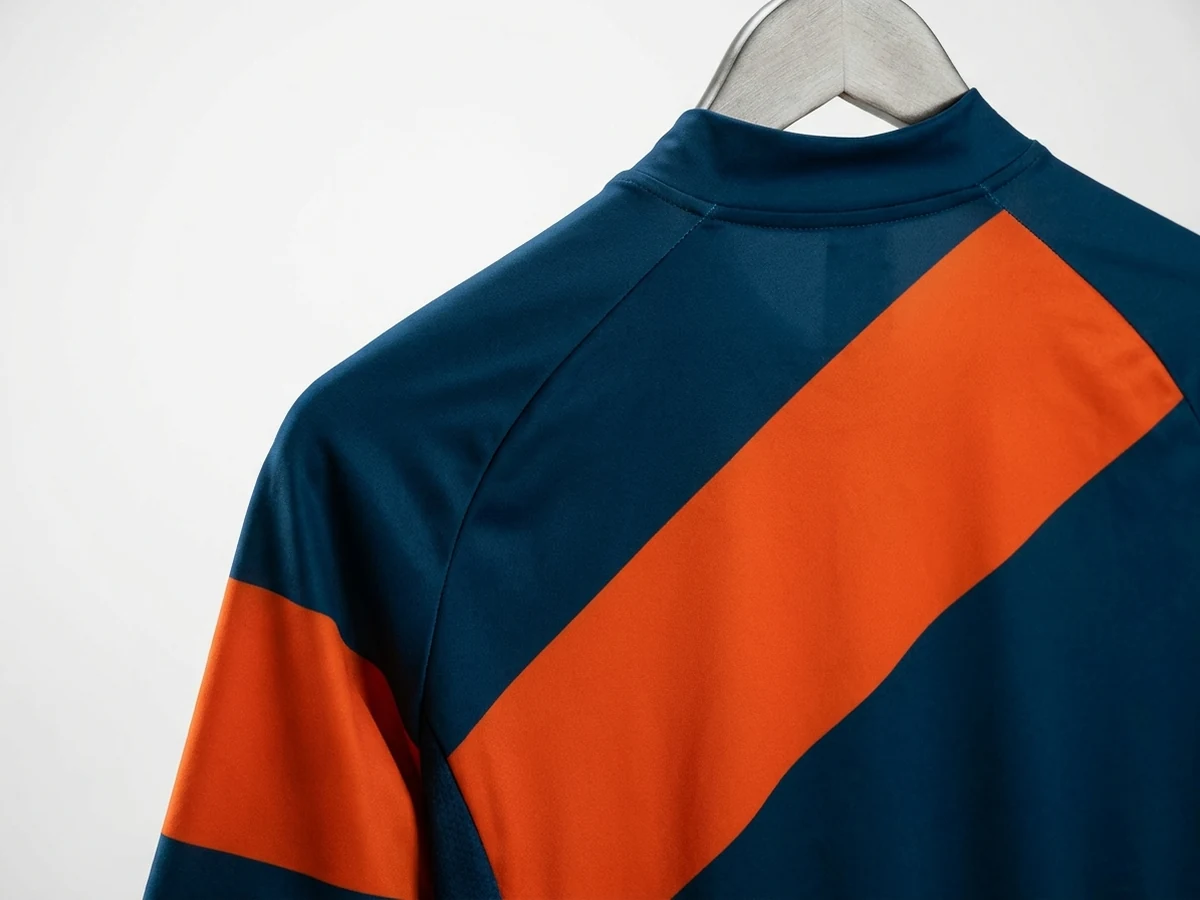 Shoulder and upper back of a navy jersey with an orange colour-blocked band