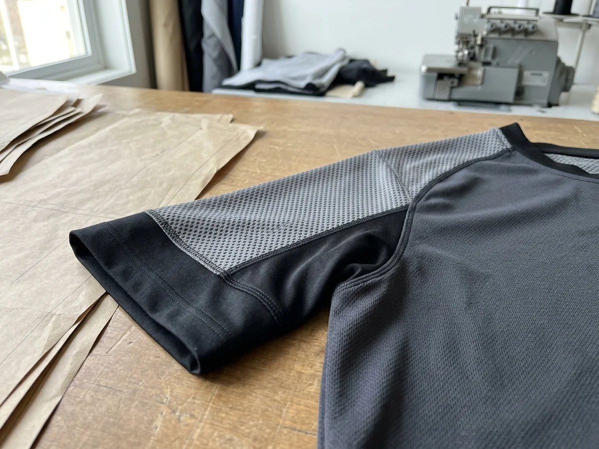 Shoulder, armhole and cuff of a knitted sports shirt laid flat