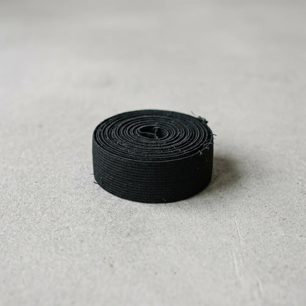 A short length of wide flat elastic band coiled into a neat roll