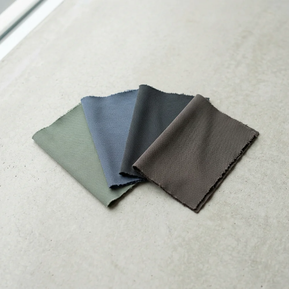 A fan of four performance knit swatches in muted solid colours